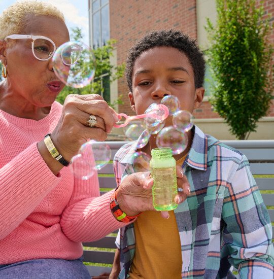 grandmother and grandson blowing bubbles